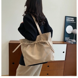 Détail d'un grand sac fourre-tout beige avec plis à cordon sur cuir synthétique souple
