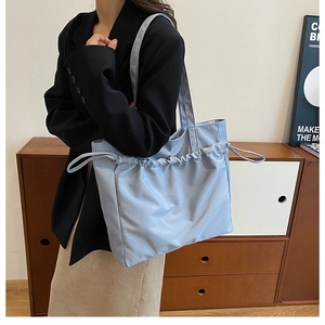Détail d'un sac cabas bleu en nylon imperméable avec cordon de serrage et texture plissée