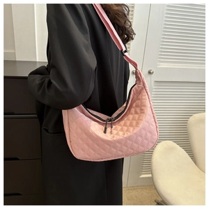 Detail view of pink quilted nylon crossbody bag with adjustable black strap and zipper
