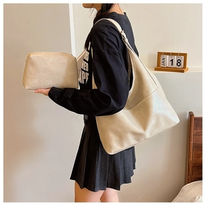 Detail view of the beige PU leather tote bag set shown on model with matching pouch