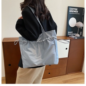 Vue détaillée du grand sac cabas bleu clair imperméable avec détail cordon sur l'épaule