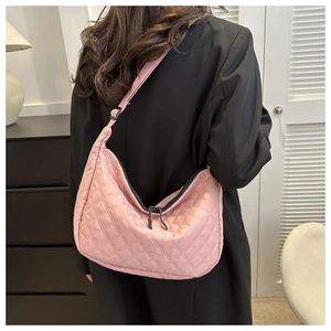 Pink quilted nylon crossbody bag shown worn over a black blazer for a casual look