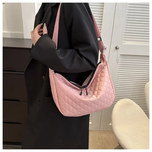 Detail of pink quilted nylon crossbody bag featuring double zippers and wide strap
