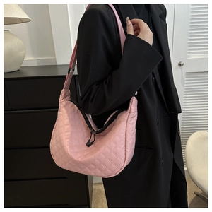 Detailed shot of a pink quilted nylon crescent bag featuring a stylish wide strap
