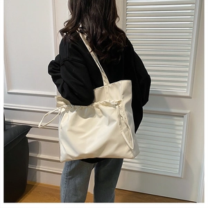 Gros plan du grand sac cabas crème montrant le cordon de serrage et la texture nylon