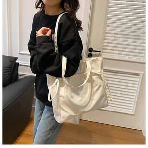 Détail du grand sac cabas blanc avec cordon de serrage latéral et bretelles réglables
