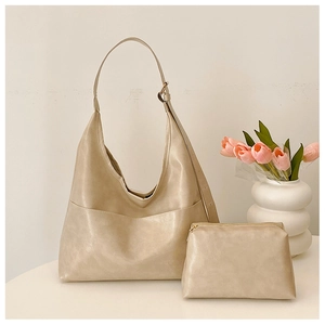 Detail showing off-white tote bag with adjustable strap and matching small zipper pouch