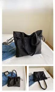 Vue détaillée du grand sac cabas noir imperméable avec fermeture à cordon et anses en tissu