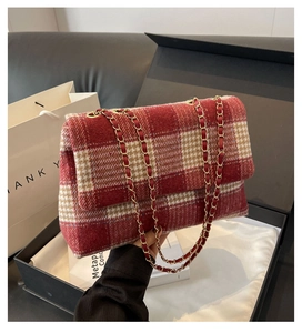 Dettaglio della borsa in tweed a quadri rossi e crema in una confezione regalo nera di lusso