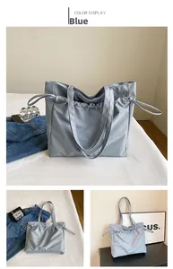 Détail du grand sac cabas en nylon bleu montrant le tissu imperméable et le cordon de serrage