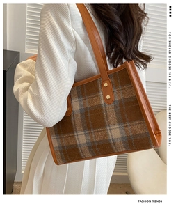 Detailansicht der Vintage-Karo-Tragetasche mit braunen Ledergriffen und goldenen Nieten