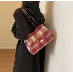Vista dettagliata della borsa a tracolla in tweed a quadri rossa e beige con catena in metallo