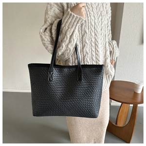 Détail du grand sac cabas noir tissé avec une texture en cuir tressé et grande capacité