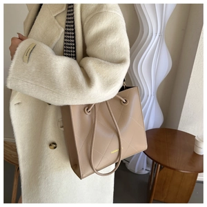 Dettaglio della borsa tote in pelle trapuntata kaki con tracolla pied de poule