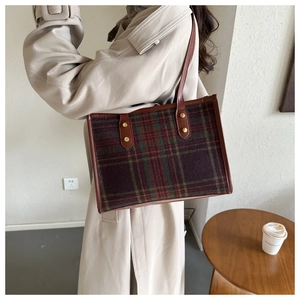 Detailaufnahme der Vintage-Karo-Einkaufstasche aus Wolle mit Lederbesatz und Goldnieten