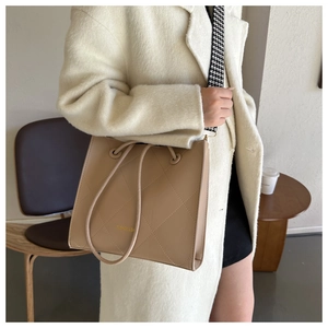 Borsa tote trapuntata con testo moda e tracolla pied de poule su cappotto beige