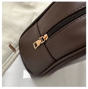 Close-up of champagne gold zipper detail on vintage brown minimalist shell shoulder bag