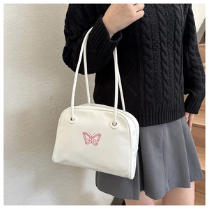 Detailed embroidery of pink butterfly pattern on white faux leather shoulder bag