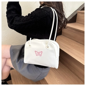 Detail showing pink butterfly embroidery on white leather underarm shoulder shell bag