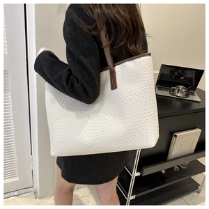 Détail du grand sac cabas blanc à texture tressée et anses en cuir marron