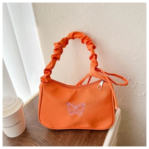 Detalle de bolso baguette naranja con bordado de mariposa y asa fruncida