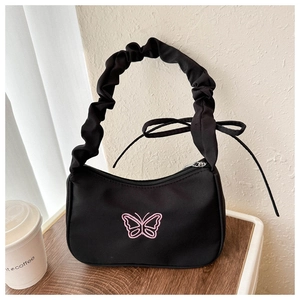 Detalle de bordado de mariposa rosa y correa fruncida en bolso hobo negro chic