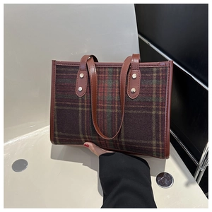 Detail der Vintage-Plaid-Wolle mit braunem Lederbesatz und Akzenten aus Metallnieten
