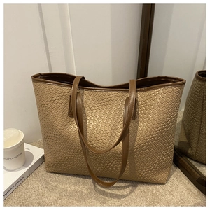 Close-up of beige woven texture and dark brown leather trim on a large tote bag