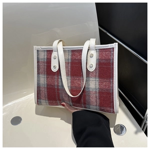 Detailansicht der karierten Woll-Tote-Bag in Rot und Grau mit weißen Lederriemen