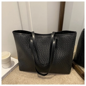 Detail shot of black woven leather tote bag with long shoulder straps for daily use
