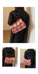 Dettaglio borsa a tracolla scozzese rossa e beige con cinturino a catena sulla modella