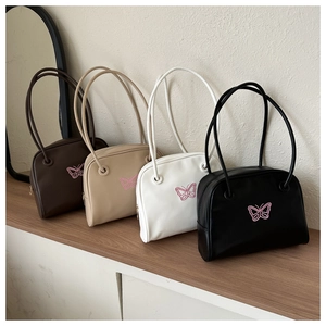 Close-up of stylish shell bags in four colors with delicate pink butterfly embroidery