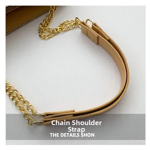 Détail de la chaîne en métal doré et de la bandoulière en cuir kaki avec couture fine