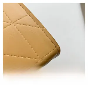 Gros plan sur un sac en cuir beige avec détails de surpiqûres matelassées en losange
