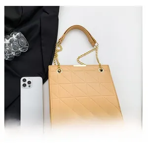 Comparaison de taille du sac beige matelassé avec smartphone et détails dorés