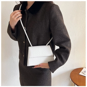 Borsa a tracolla bianca con motivo coccodrillo su modella con un blazer vintage