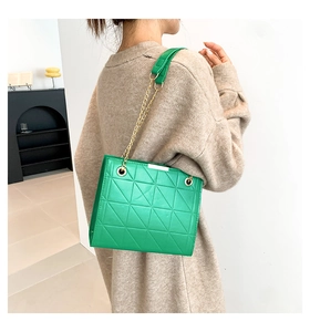 Détail du sac bandoulière matelassé vert vif avec chaîne dorée et bandoulière en cuir