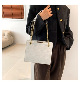 Détail du sac cabas blanc matelassé avec coutures géométriques et chaîne dorée