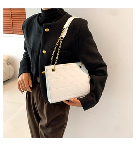 Gros plan sur le sac bandoulière blanc matelassé avec boucle dorée et chaîne élégante