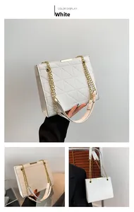 Détail du sac cabas blanc matelassé avec chaîne dorée et barre métallique supérieure