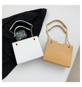 Détail de deux sacs cabas matelassés blanc et kaki avec motifs géométriques et chaîne