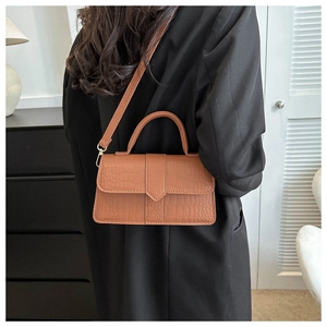 Sac bandoulière classique marron gaufré crocodile avec poignée porté par mannequin