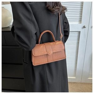 Détail d'un sac carré marron à motif crocodile en similicuir avec boucle métallique chic