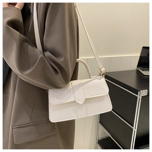 Gros plan du sac blanc à motif crocodile avec finitions dorées et fine bandoulière