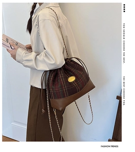 Fashion plaid wool bucket bag worn by model with chain strap and drawstring detail