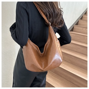 Vintage brown leather hobo bag with wide shoulder strap for casual daily use