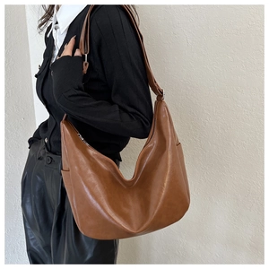 Detail of caramel brown hobo bag showing large capacity and smooth faux leather texture