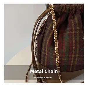 Detail of the high-quality gold metal chain strap on the textured plaid wool bucket bag