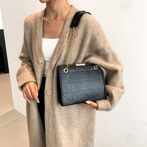 Sac bandoulière noir matelassé avec chaîne dorée et détails métalliques élégants