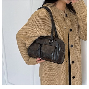 Borsa a spalla vintage in pelle PU marrone scuro con tasche anteriori su una modella